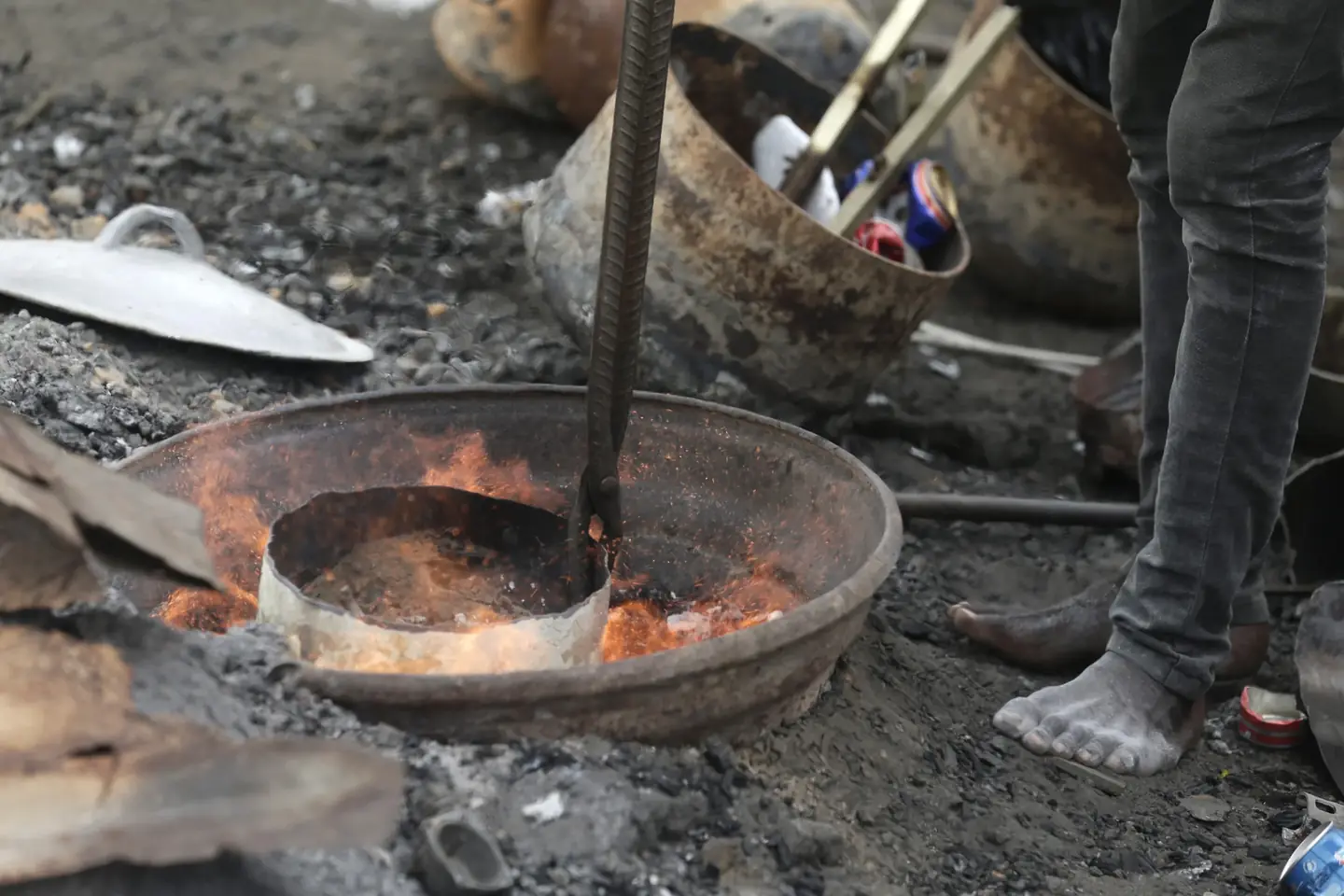 Scrap metal being smelted over an open fire